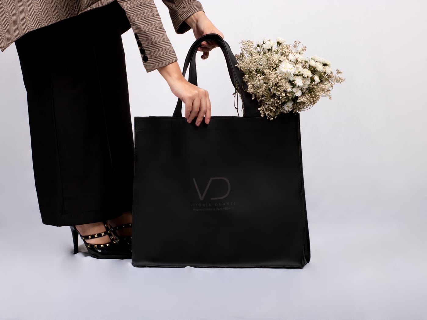 Bolsa com a marca VD Arquitetura e flores, identidade visual do escritório